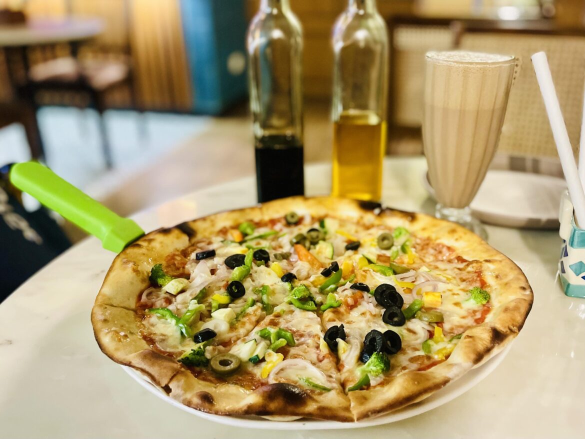 Veggie-loaded pizza topped with olives, bell peppers, onions, and broccoli. [I Ate]