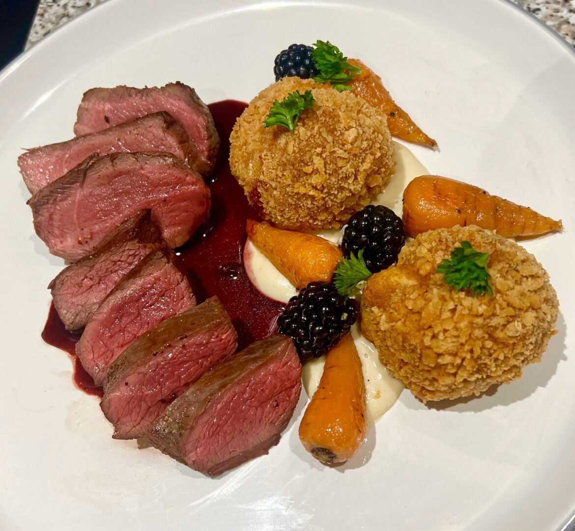 Venison steak with Parsnip Purée, Crispy Potato Croquettes, Glazed Baby Carrots, and a Blackberry Red Wine Sauce