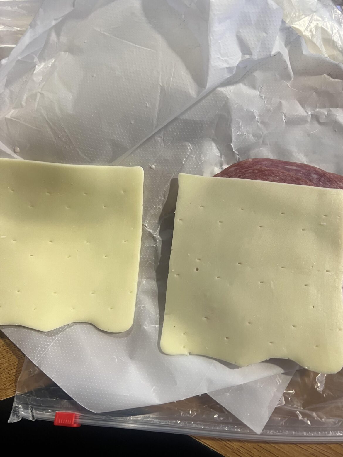 What are these uniform rectangular holes in my Primo Taglio brand white american cheese? Never seen this before