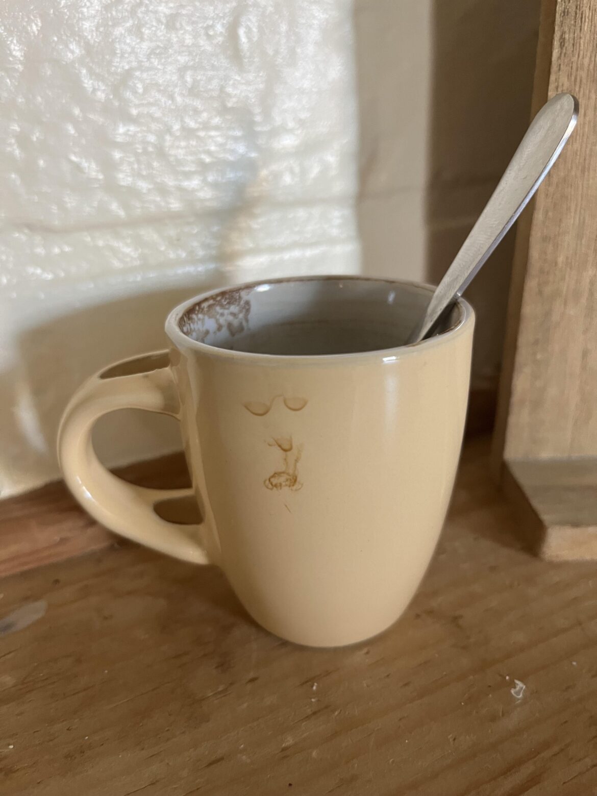 Espresso mini mug drippings made a tired face with stinky coffee breath standing off