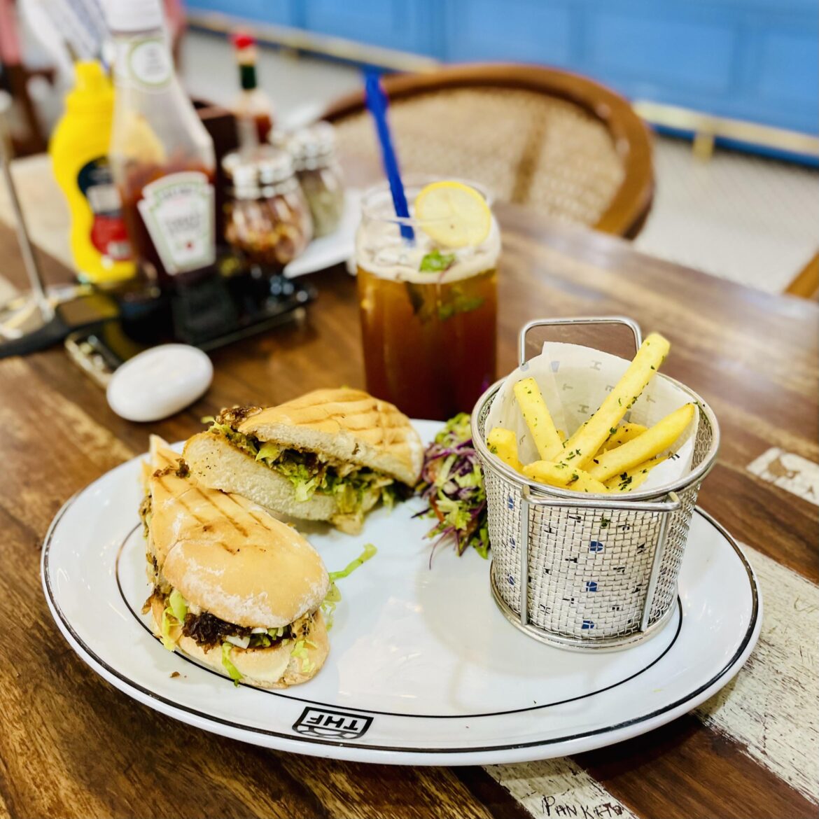 Iced lemon tea with a grilled sandwich filled with shredded veggies and herbs, served with a side of golden fries and coleslaw [I Ate] [OC]