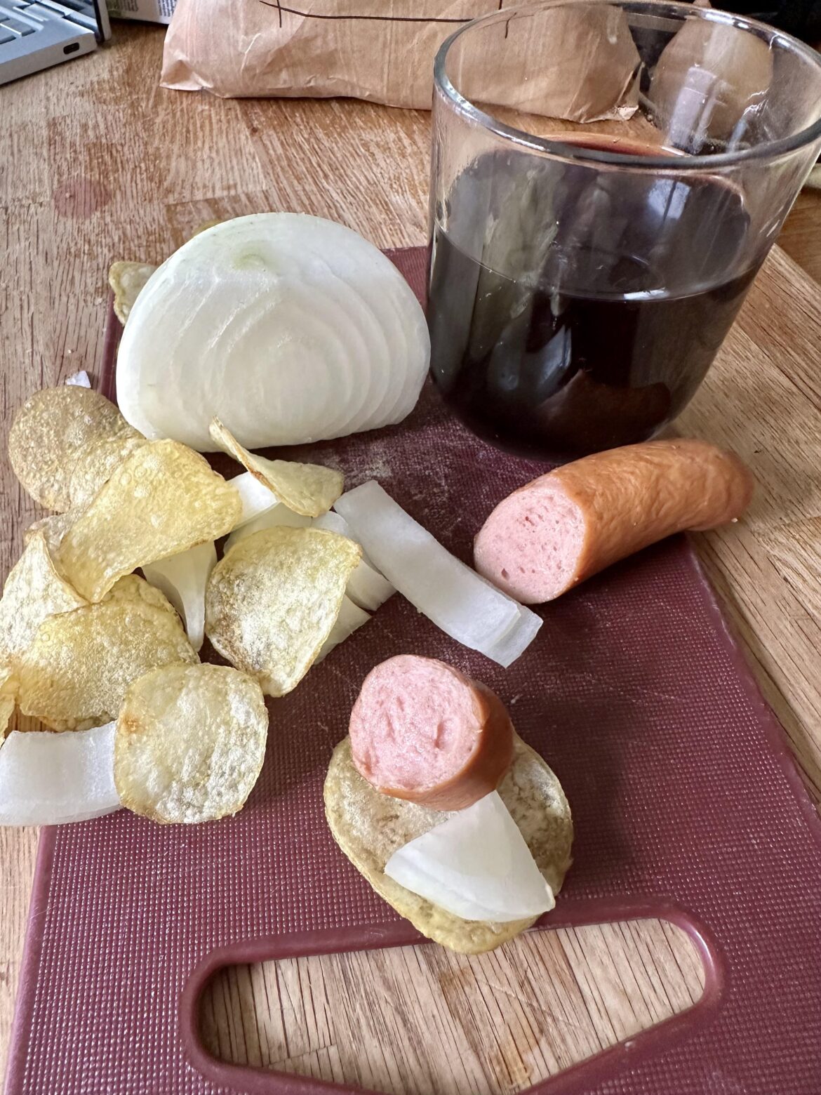 Raw onions on chips and frankfurter.