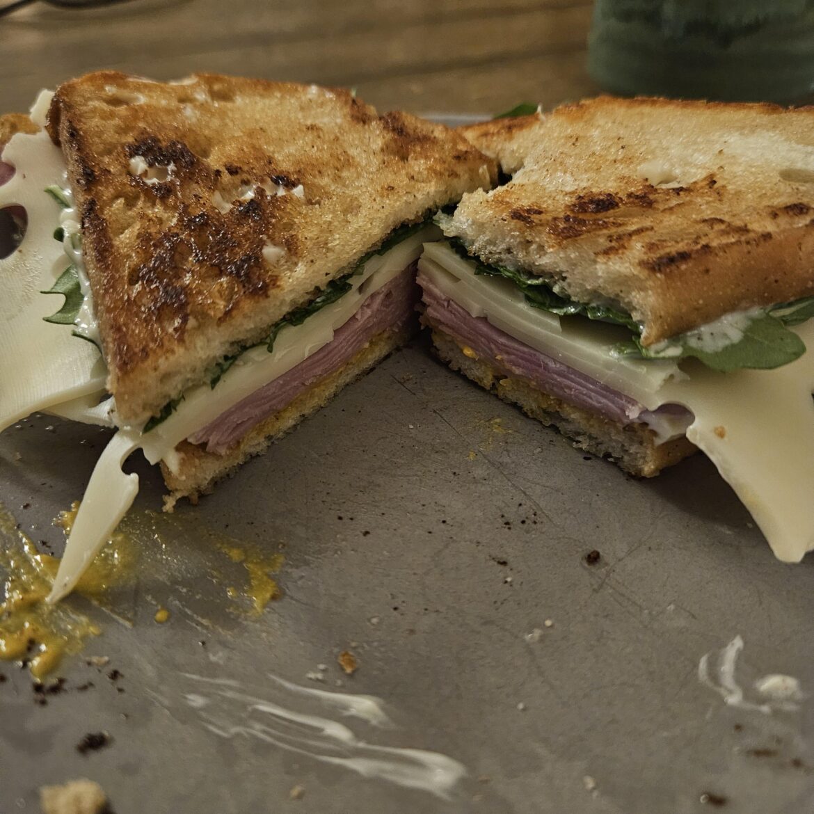 Ham, Swiss, and arugula on toasted sourdough w mayo and yellow mustard.