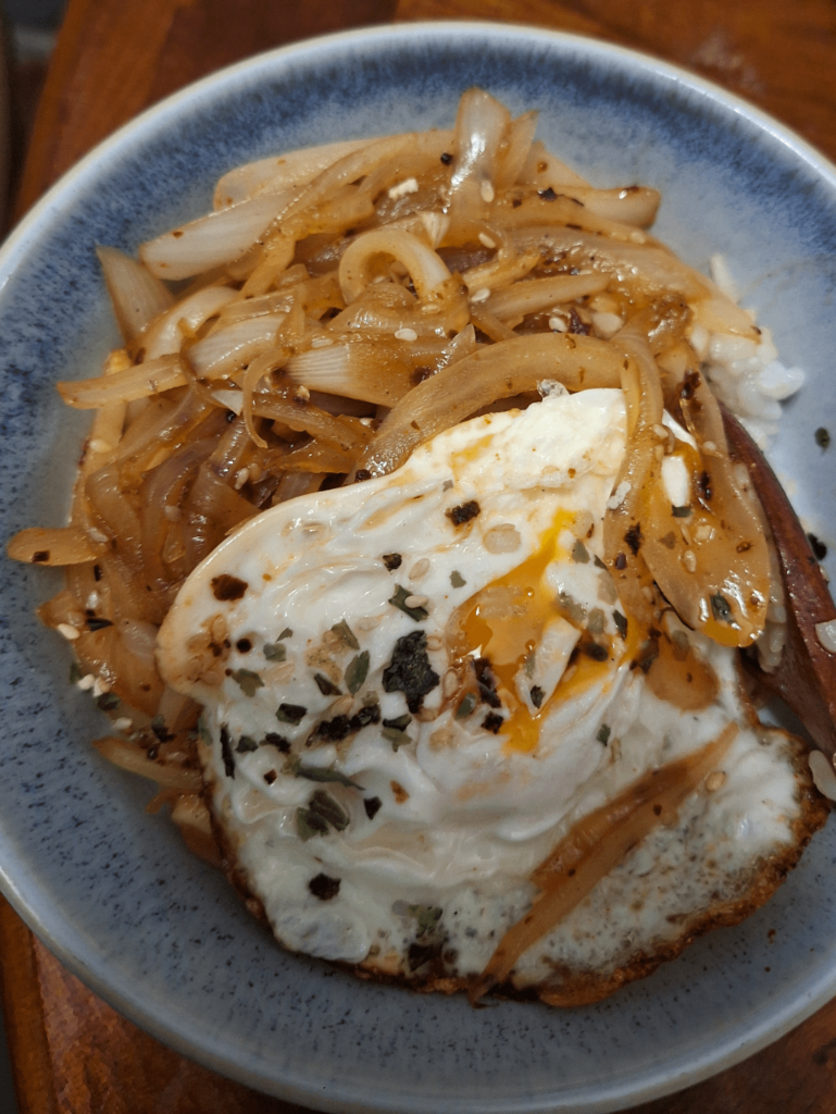 Stir fried onions on rice (with an egg)