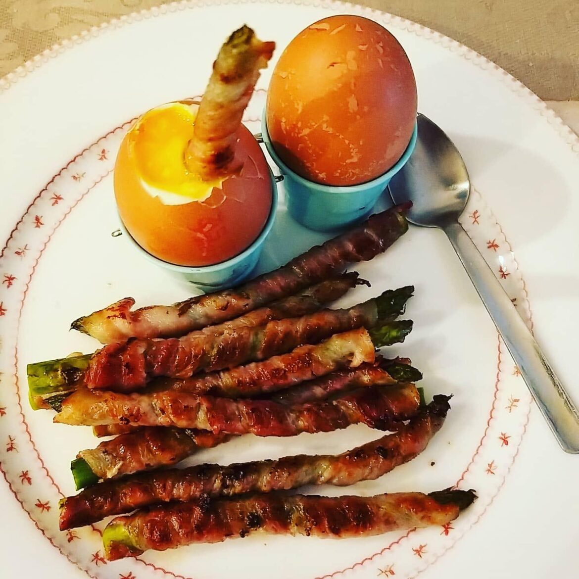 Savory bacon-wrapped asparagus served with a runny yolk for dipping