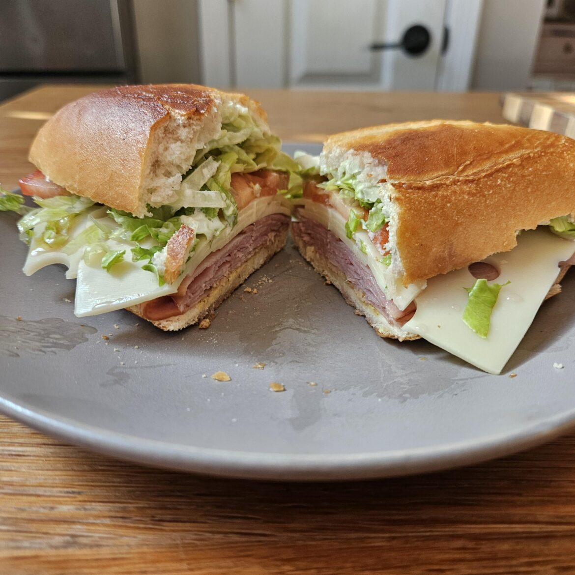 Honey baked ham, Swiss, chopped lettuce and sliced tomato on a toasted bolilo roll with mayo and spicy mustard, drizzled with oil and vinegar.