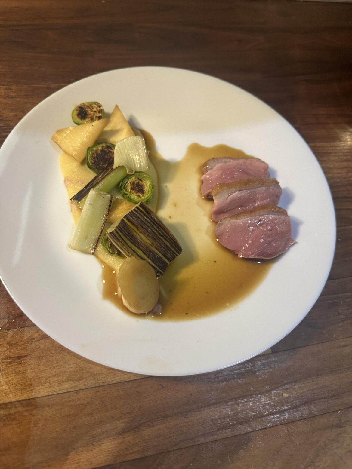 Roasted duck breast, charred leeks and Brussels sprouts, parsnip and truffle polenta with venison jus