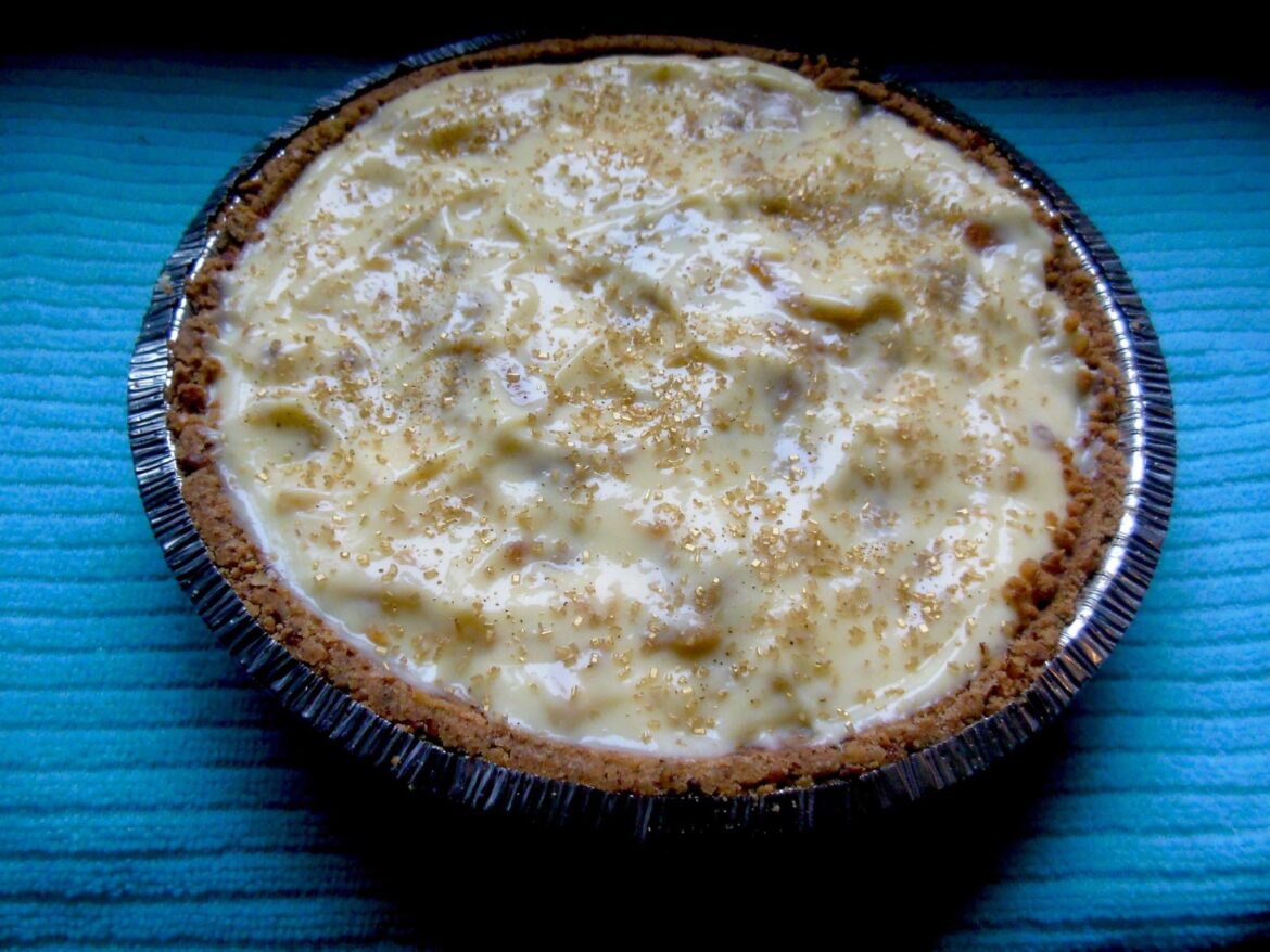 an easy but impressive and pretty no-bake pie - banana cream pudding, filled with slices of baby bananas sauteed in butter and brown sugar, in a fancy-pants store-bought walnut crust and topped with gold glitter sugar.