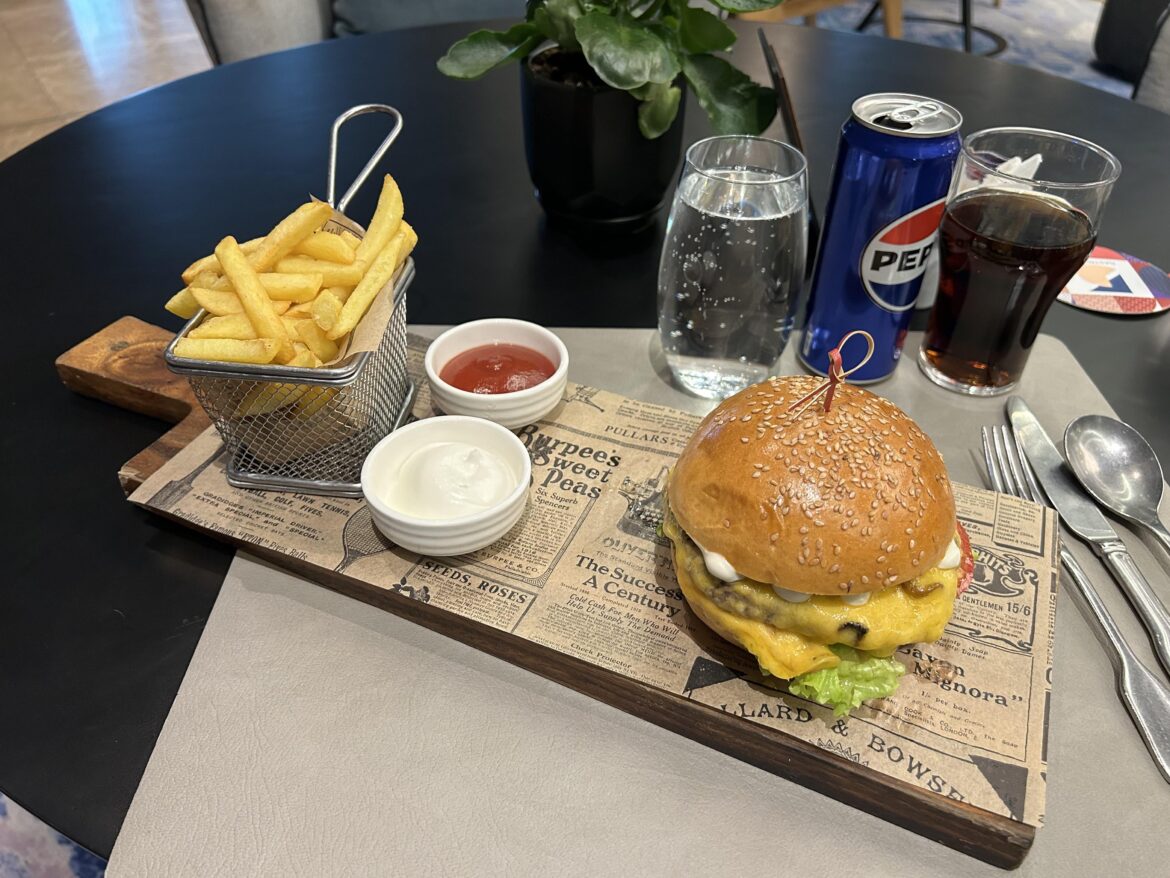 Fries in a Basket on a Board with a Burger
