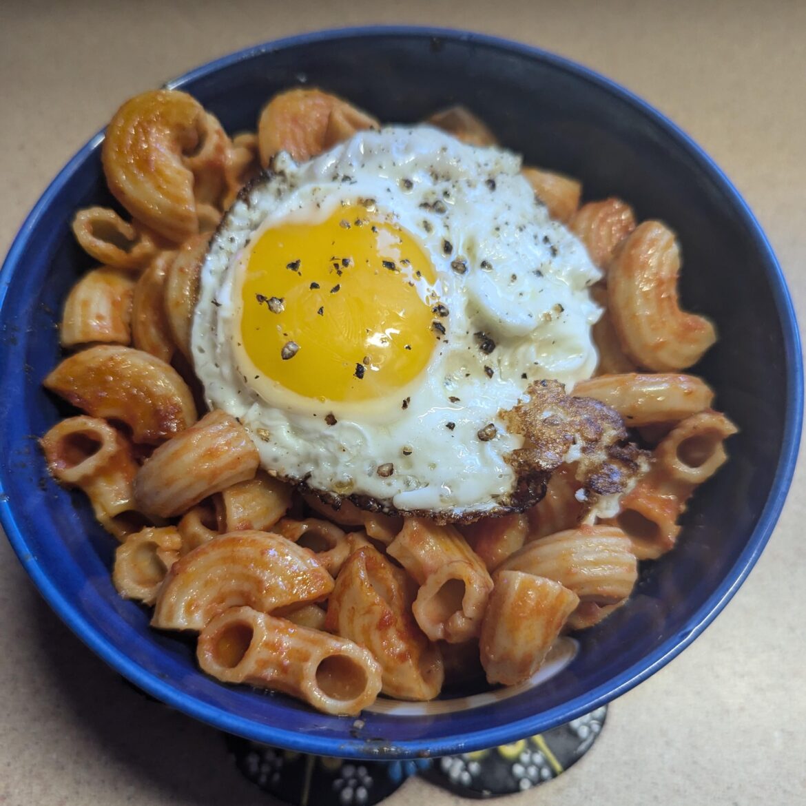 Leftover macaroni and tomatoes with a crispy egg
