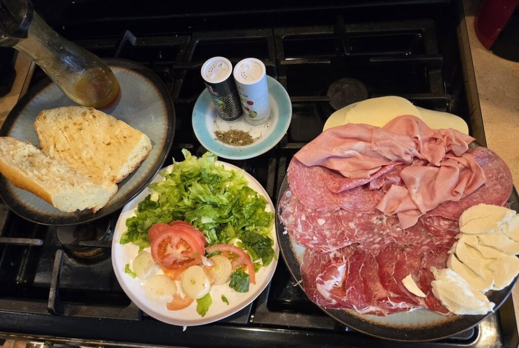 Provolone, mortadella, sopresatta, fresh mozzarella, hot gabagool, salami lettuce tomatos onions oil vinegar salt pepper oregano mangia