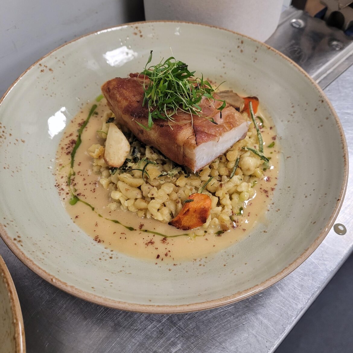 Ling cod w/ westphillian ham on a bed of mustard and herb spaetzal, carrots, parsnips, & sunchokes. Surrounded by an apple beurre blanc topped with sumac and charred leek oil