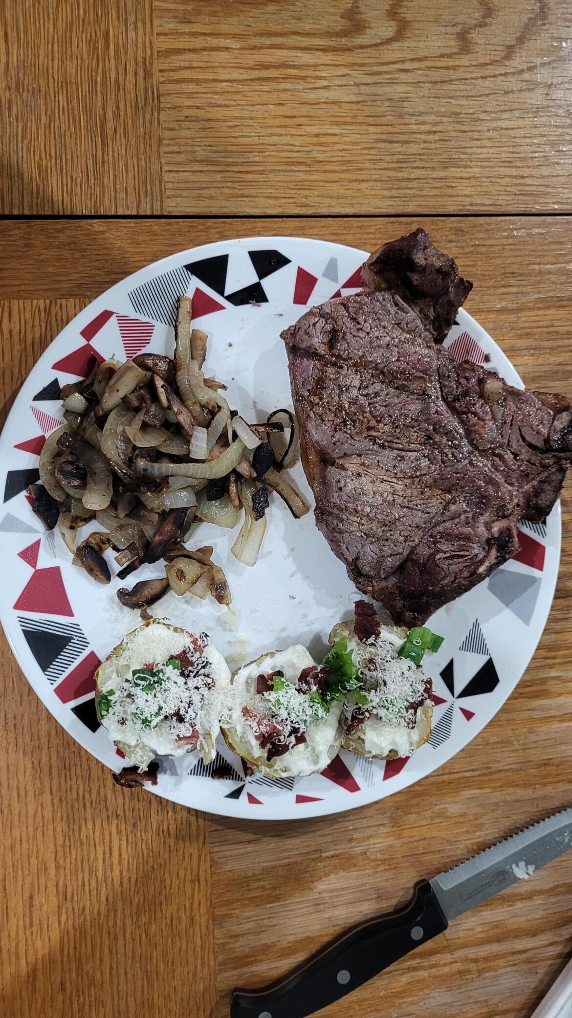 Winter grilling. Mushrooms and onions, baked potato with bacon, sour cream, and green onion.