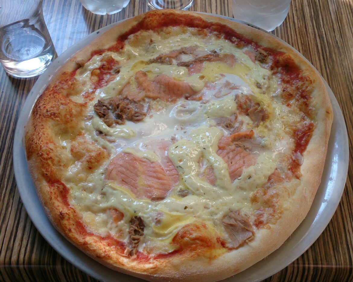 A pizza I ate in Denmark. It has salmon, tuna, egg and bearnaise sauce