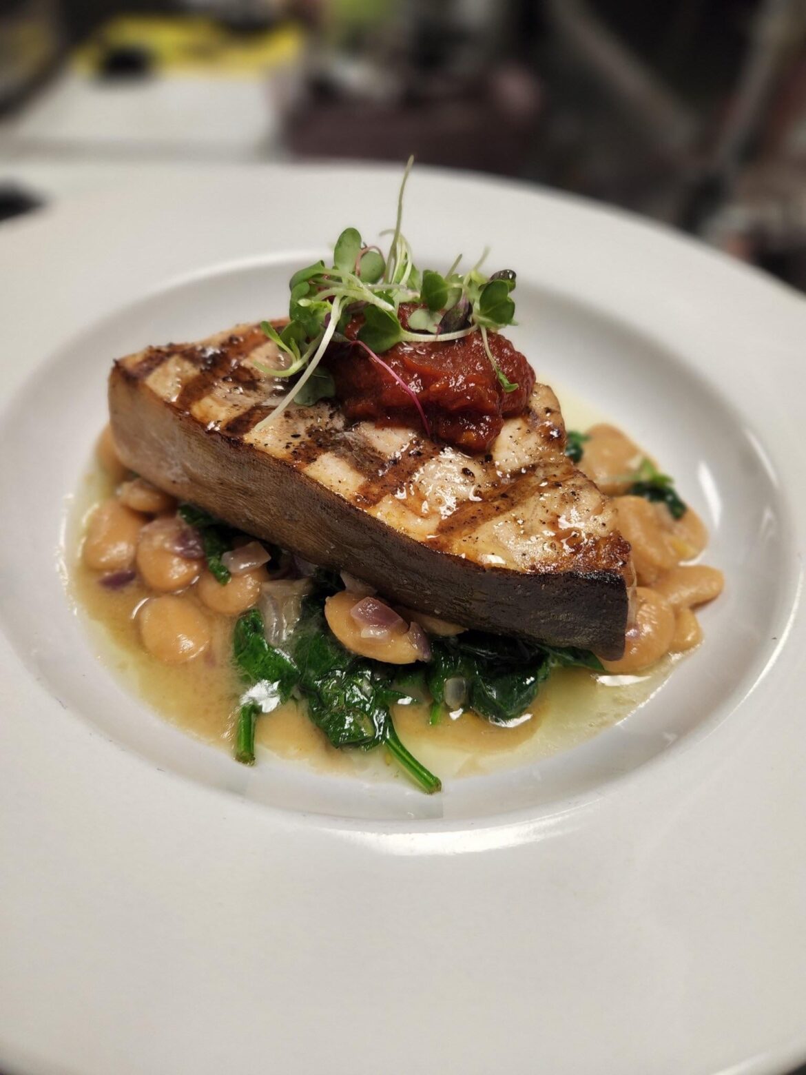 Swordfish over white beans and baby spinach topped with spicy tomato jam