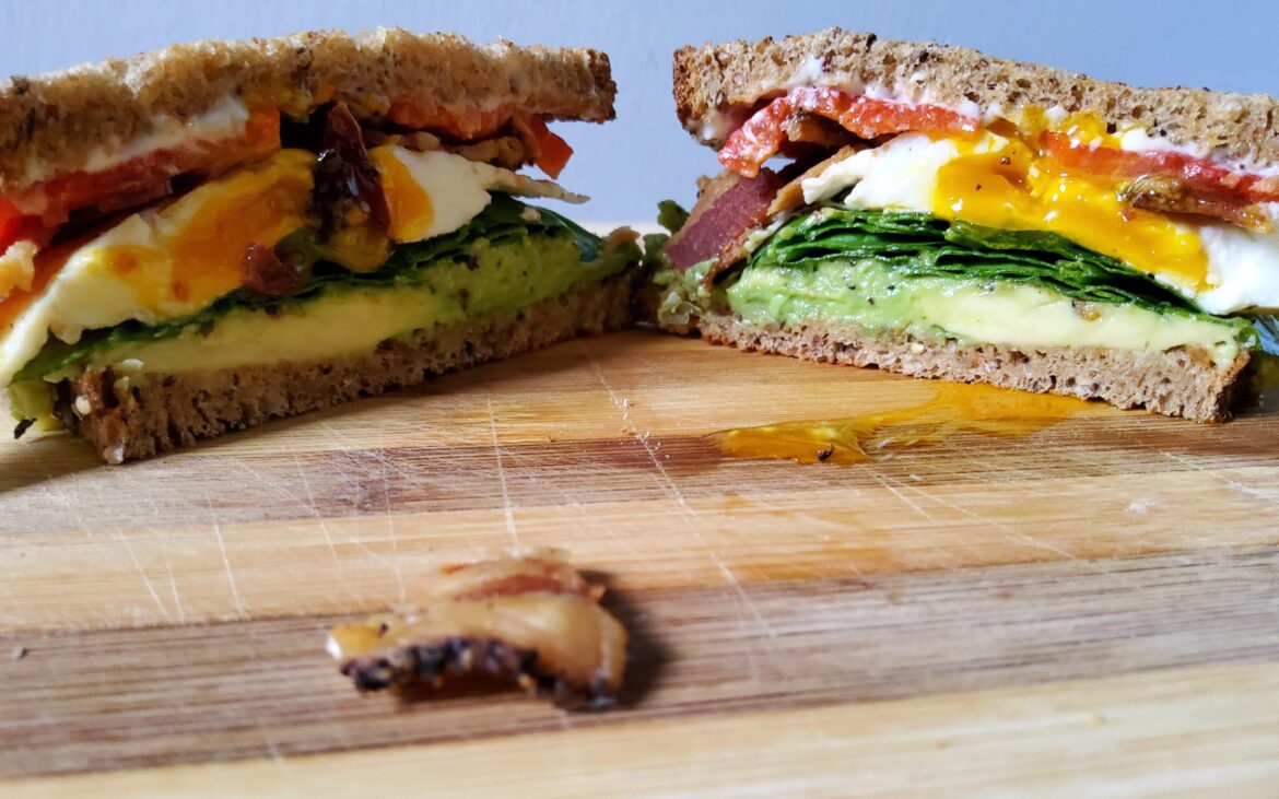 My lunch sandwich on toasted Dave's Killer bread. Starting from bottom avocado, spinach, fried egg, bacon, roasted red pepper, and Duke's mayo.
