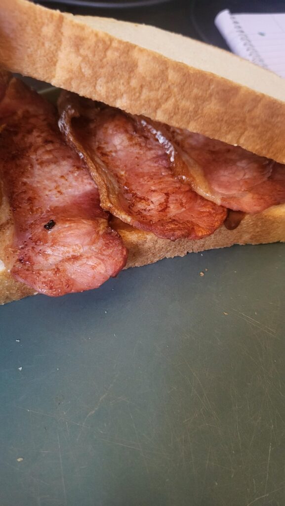 Breakfast , bacon tiger bread and brown sauce.