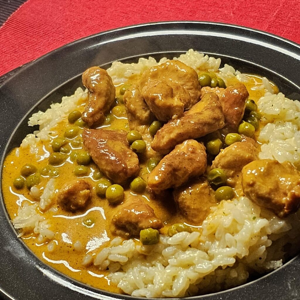 Meatballs made from Kalbsbrät (finely ground veal meat paste) served in a creamy curry sauce with white wine, honey,  peas and freshly pressed orange juice, accompanied by buttered rice