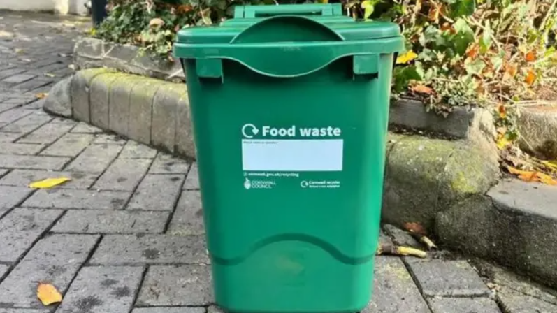 Council issues advice on food waste bins A green food waste caddy on a pavement. It has a recycling logo in white, and the text 'food waste' on the front.