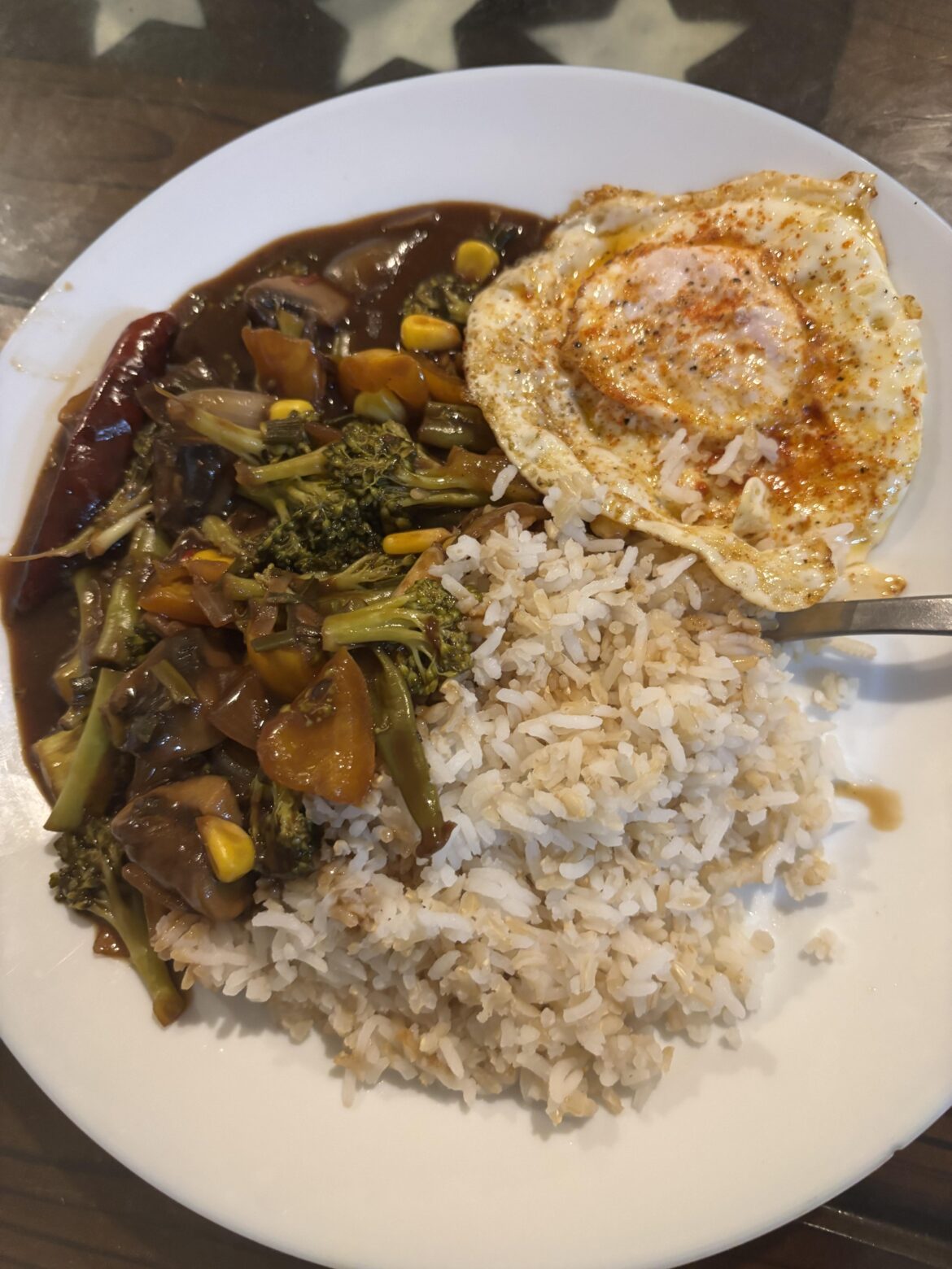Eggs go so hard with Asian food- stir fried veggies in soy garlic sauce, brown rice, and a crunchy fried egg 🤤