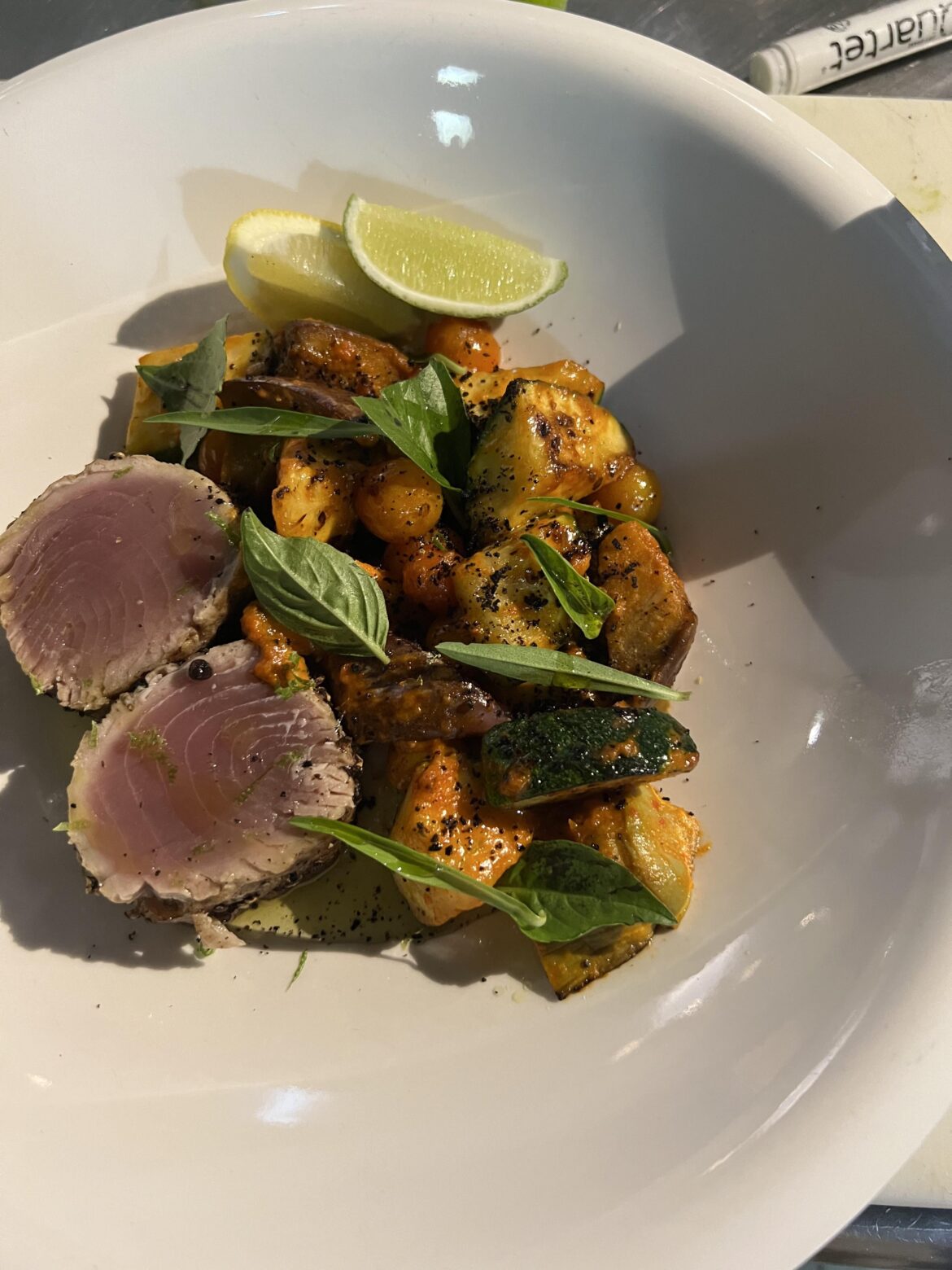 Pepper Tuna Steak with Market Vegetable Ratatouille, Olive Powder and Basil Oil.