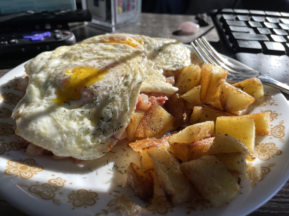 Eggs over easy, corned beef hash, & fried taters