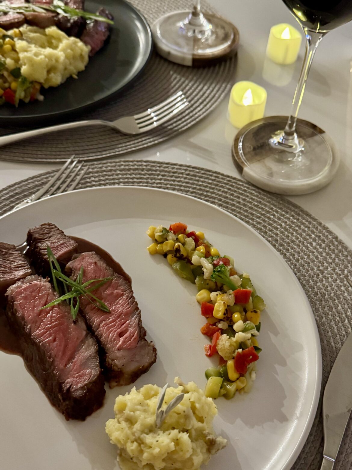 Reverse-seared ribeye with red wine and balsamic jus, rustic roadted garlic mashed potato, corn succotash