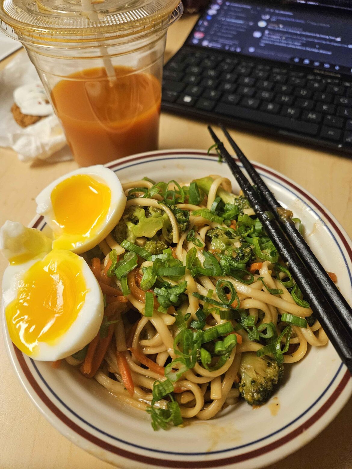 noodles, a soft boiled egg, and half a cup of thai iced tea