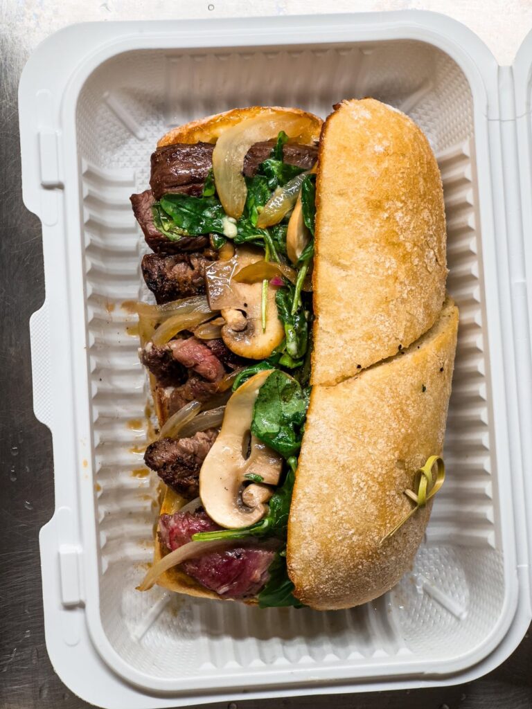 Skirt steak sandwich with mushrooms, onions and arugula. Herb fries on the slide. You guys like medium rare steak on a sandwich?