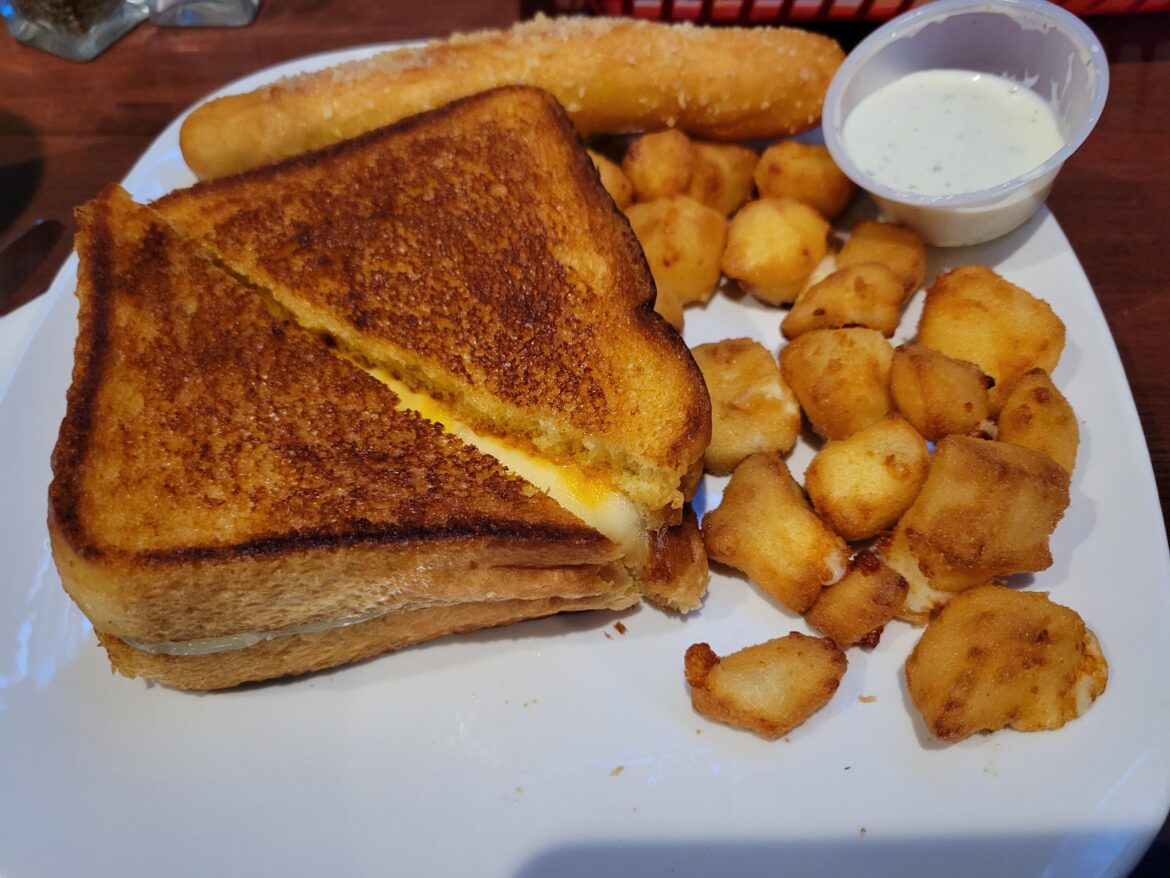 Are grilled cheese sandwich with cheese curds and a breadstick.