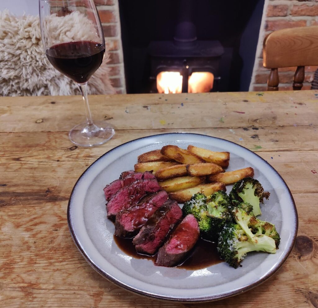 Homemade fillet steak, roast potato chips, charred broccoli, and red wine jus