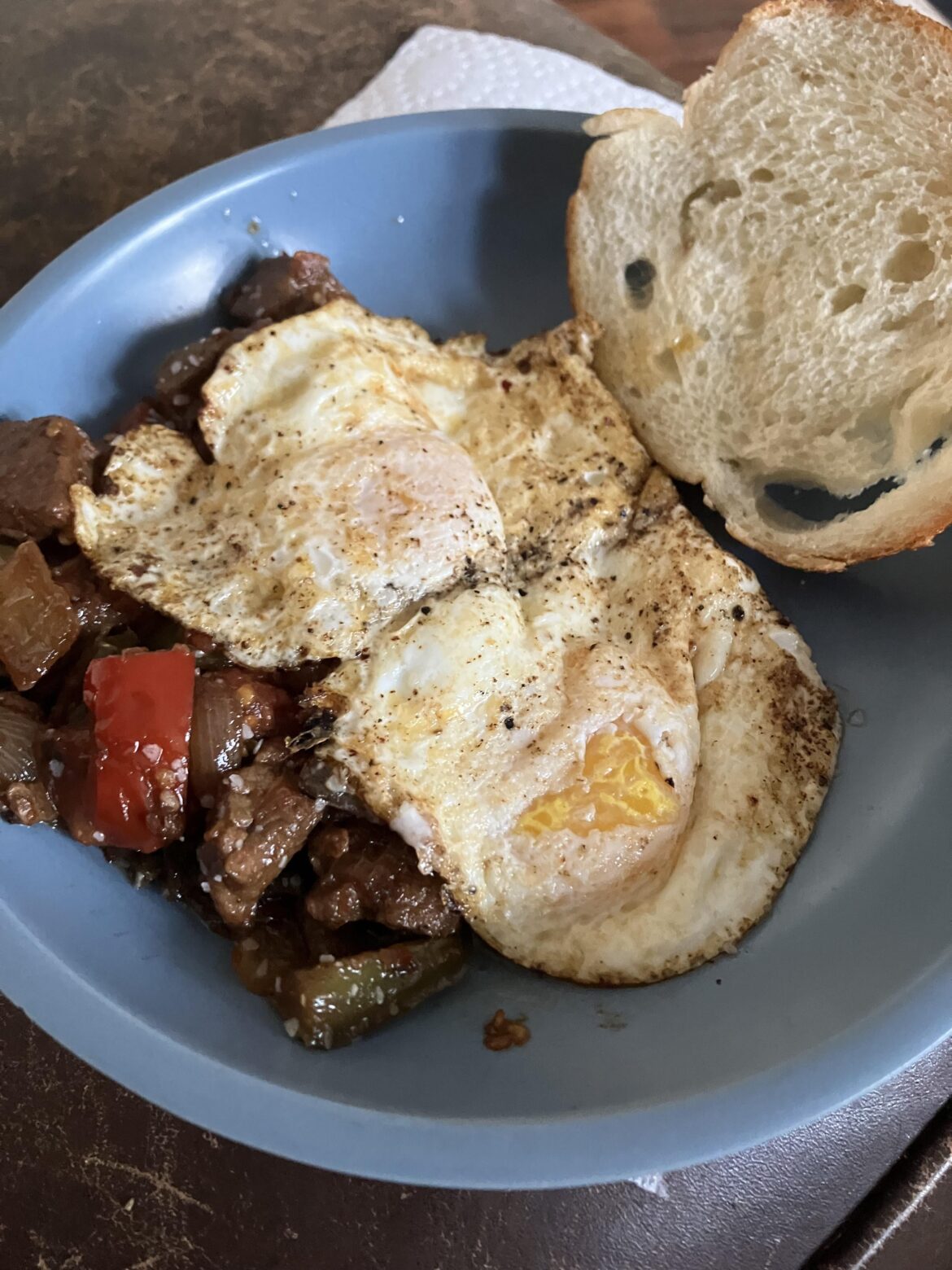 Leftover beef roasted in chili oil, peppers and tomatoes from last night, with a couple runny eggs fried in chili oil