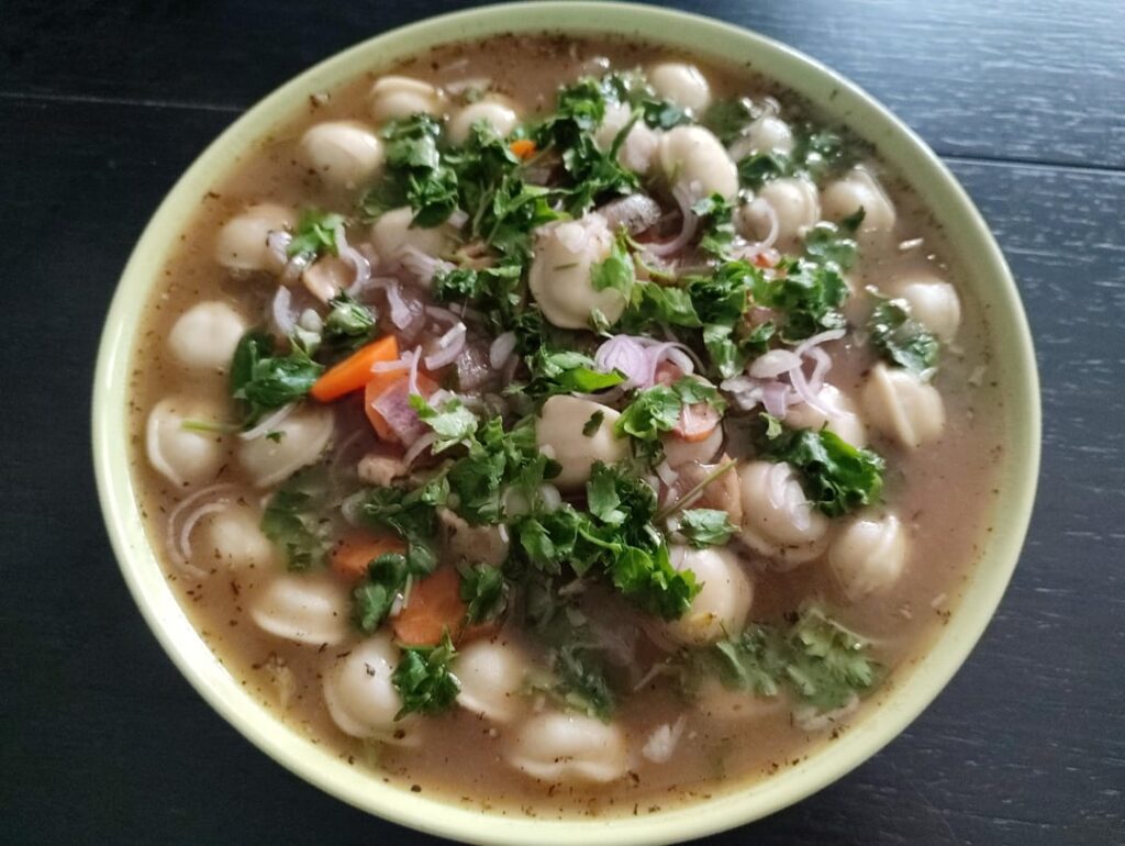 Chicken pelmeni topped with shallots and parsley