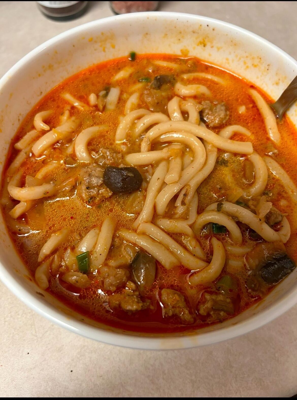 Korean chili udon with pork and black garlic.
