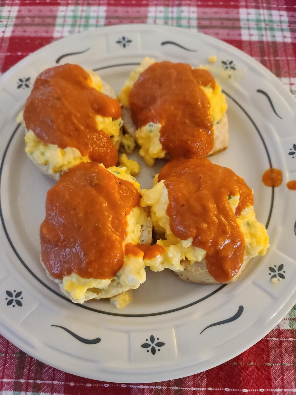 Cheesy scrambled eggs over biscuits with tomato bisque on top