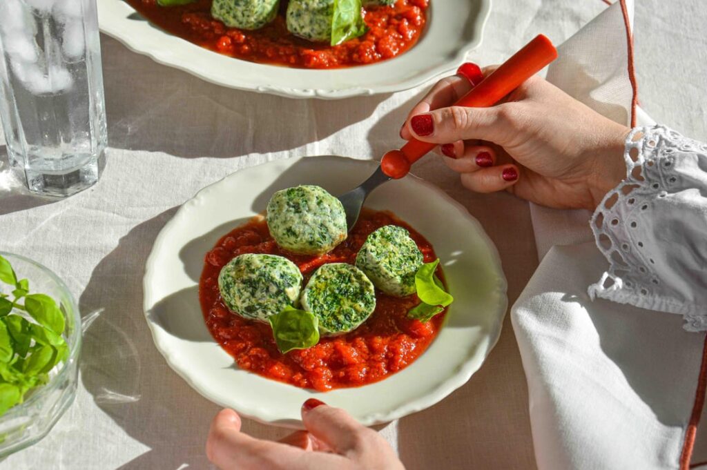 Gnudi - Tuscan dumplings made with ricotta, spinach and Parmigiano Reggiano serve in a rich tomato and basil sauce