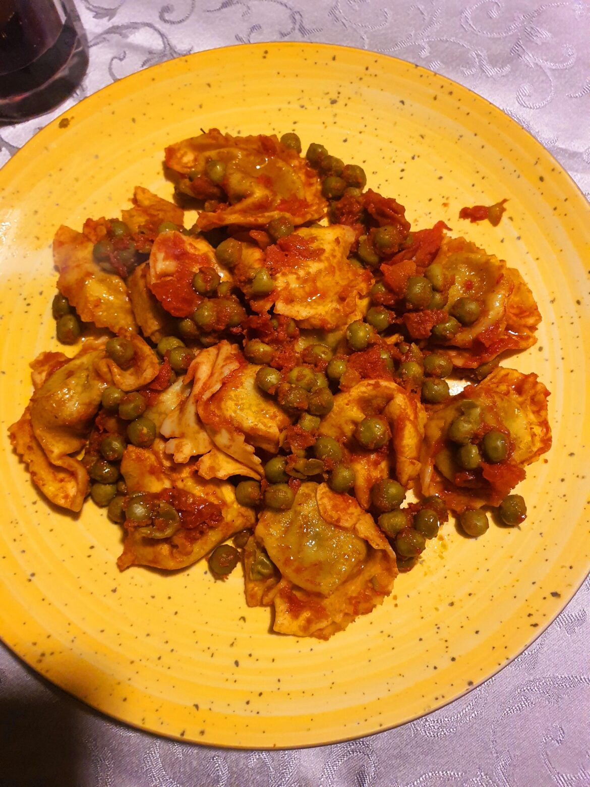Rustic tortelloni with ricotta, spinach in tomato sauce, peas.