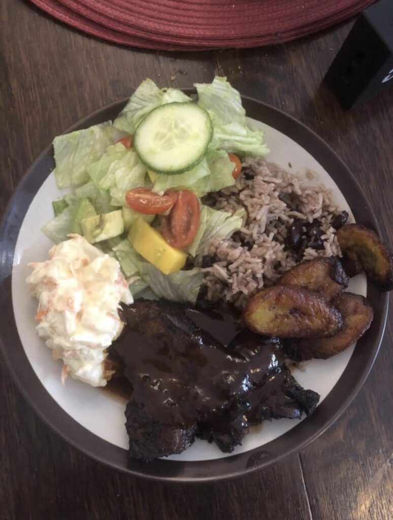 Jerk pork belly, rice and peas, mango salad, coleslaw, plantain,and a jerk bbq sauce.