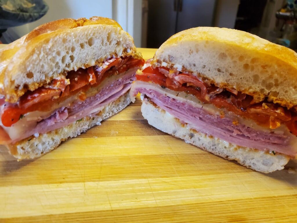 Toasted Mortadella sandwich on ciabatta with provolone and roasted peppers.