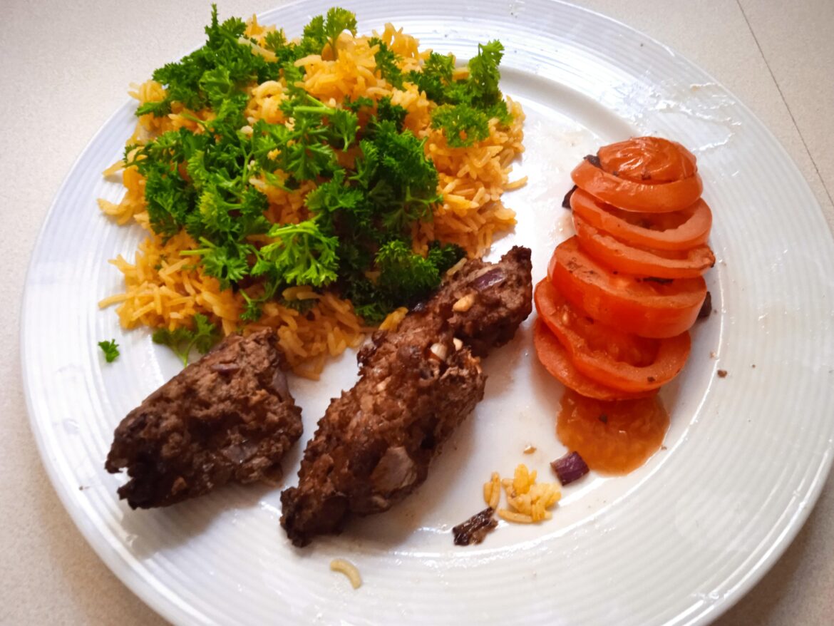 Homemade kebab tabei with pilau rice and garden parsley