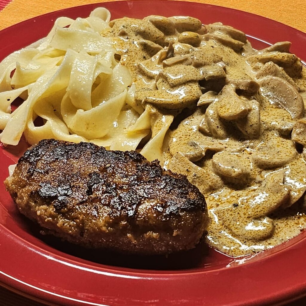 Homemade Hackbraten (meat loaf) revived from the freezer, at a creamy mushroom sauce, served with fettuccine