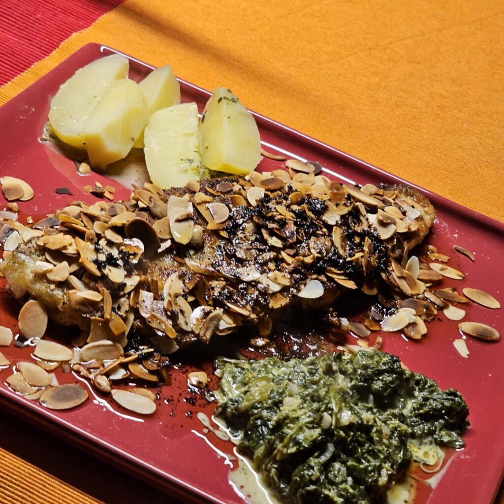 Zander topped with almonds, served with boiled potatoes and spinach