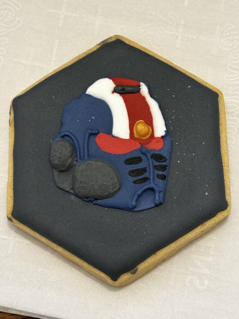 The Warhammer 40k Space Marine cookies I made for someone on this sub (reference picture for comparison)