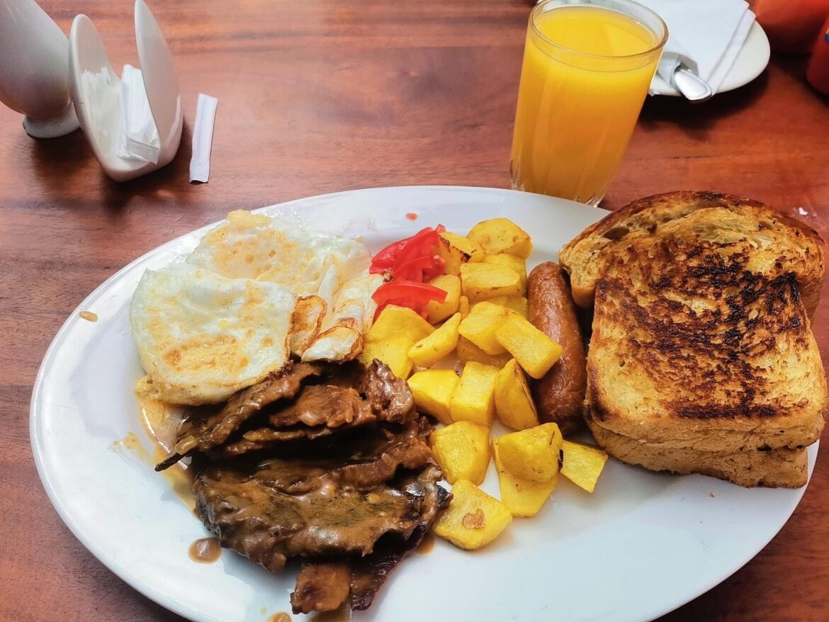 Kenyan Breakfast: Bread, eggs, Sausage, tomato, beef and Mango Juice.