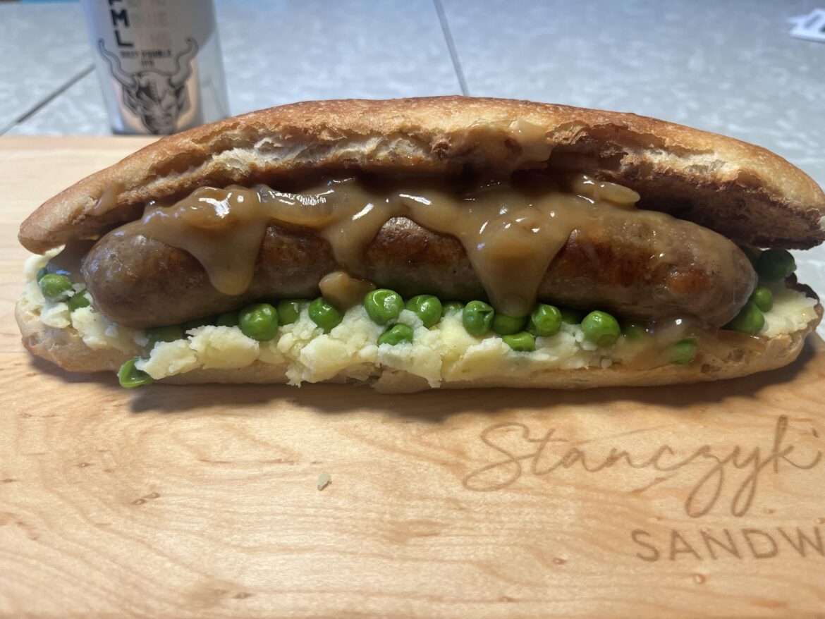 Banger and mash, with onion gravy and peas, sandwich