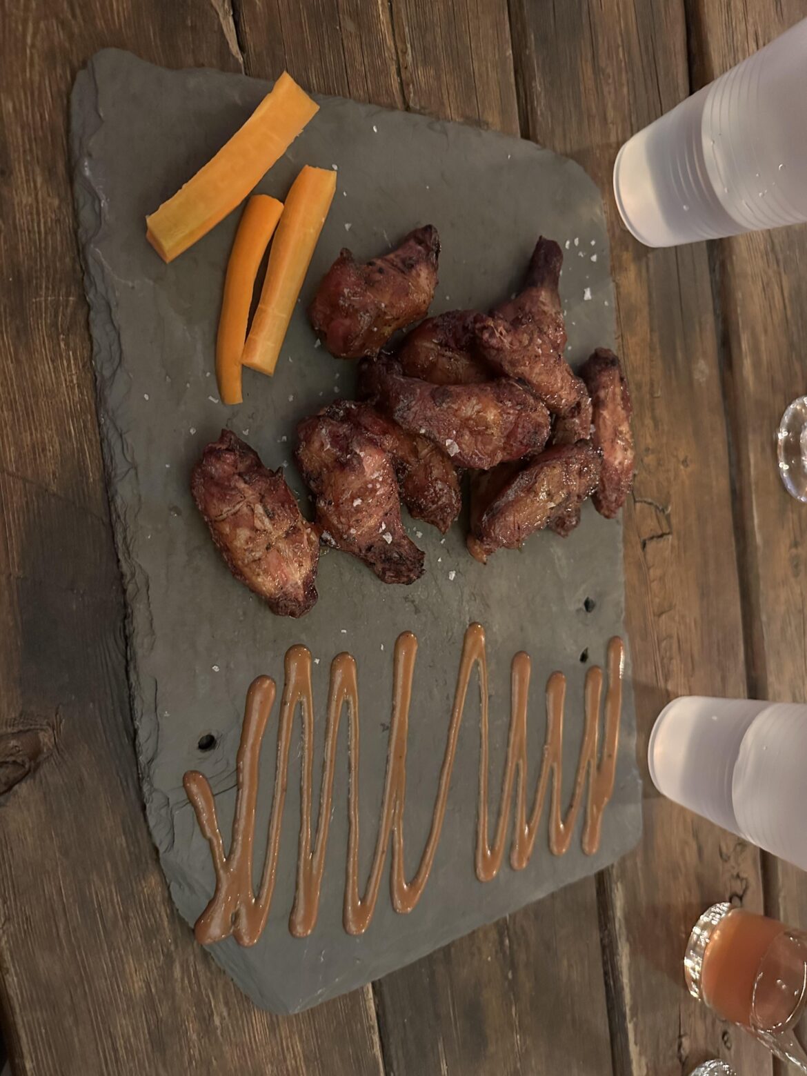 Wings served on a stone tablet. No sauce on the wings so we had to drag them across the stone to get any…