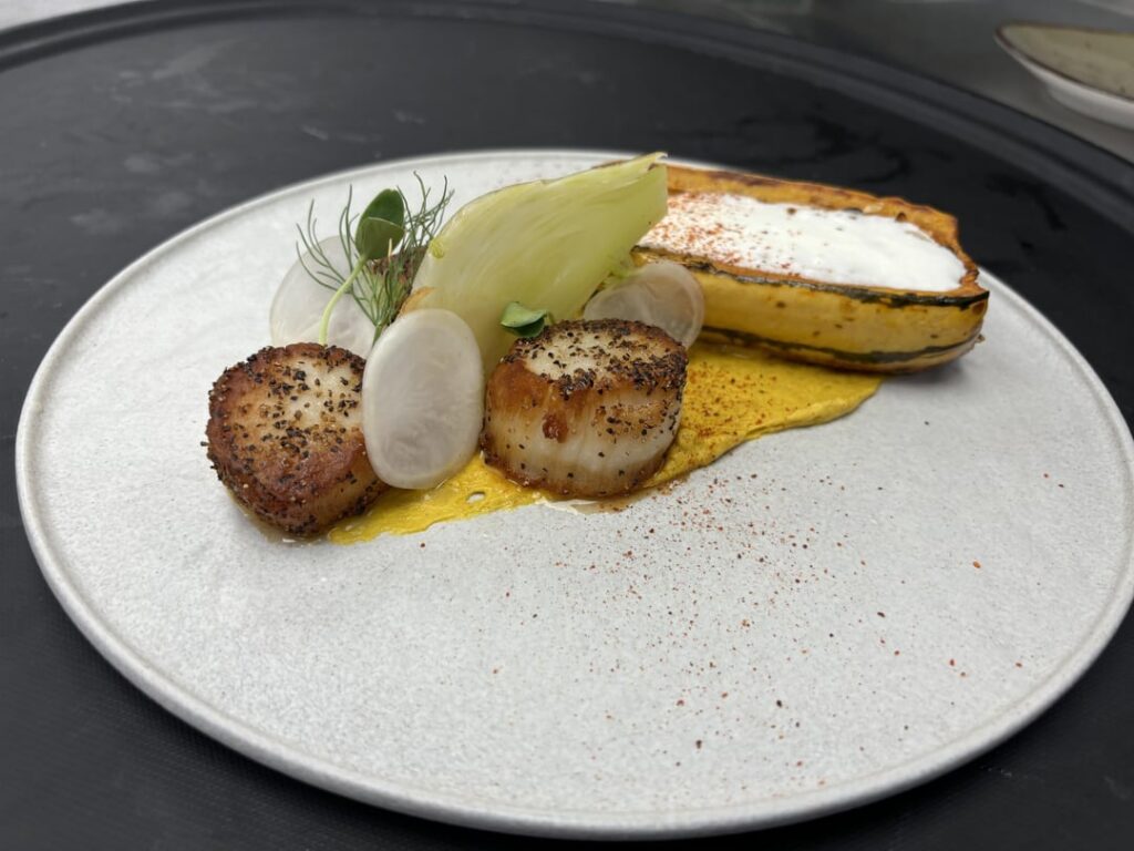 Scallops with curry sweet pot puree, aji amarillo roasted squash, age gouda foam, pickle fennel