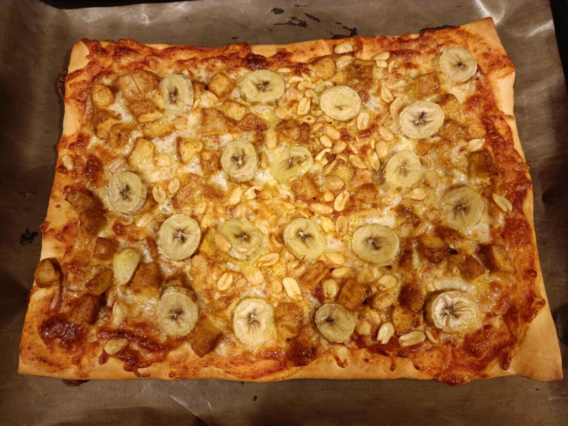 Pizza with chicken, curry, banana and lots of peanuts. And it's square.