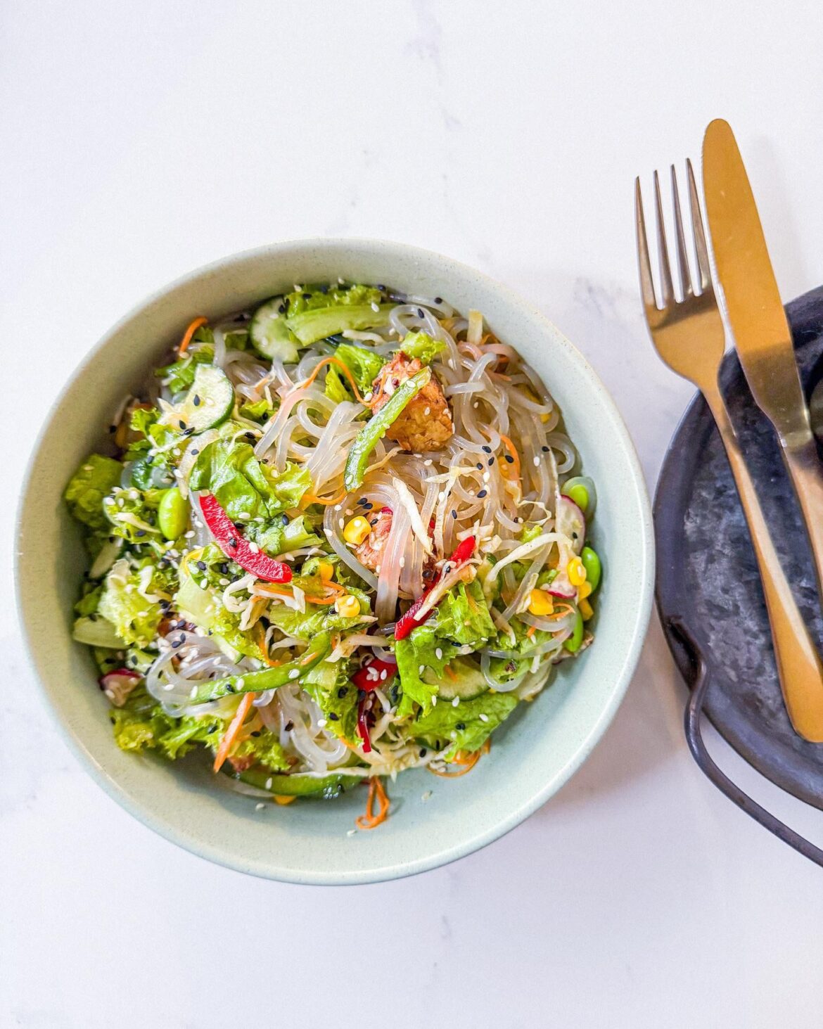 Japchae Sesame — Korean sweet potato noodles tossed in a nutty & sweet sesame dressing. This dish combines tender japchae, hearty tempeh, and crisp fresh veggies for a perfectly balanced bite. A plant-based meal worth trying today.
