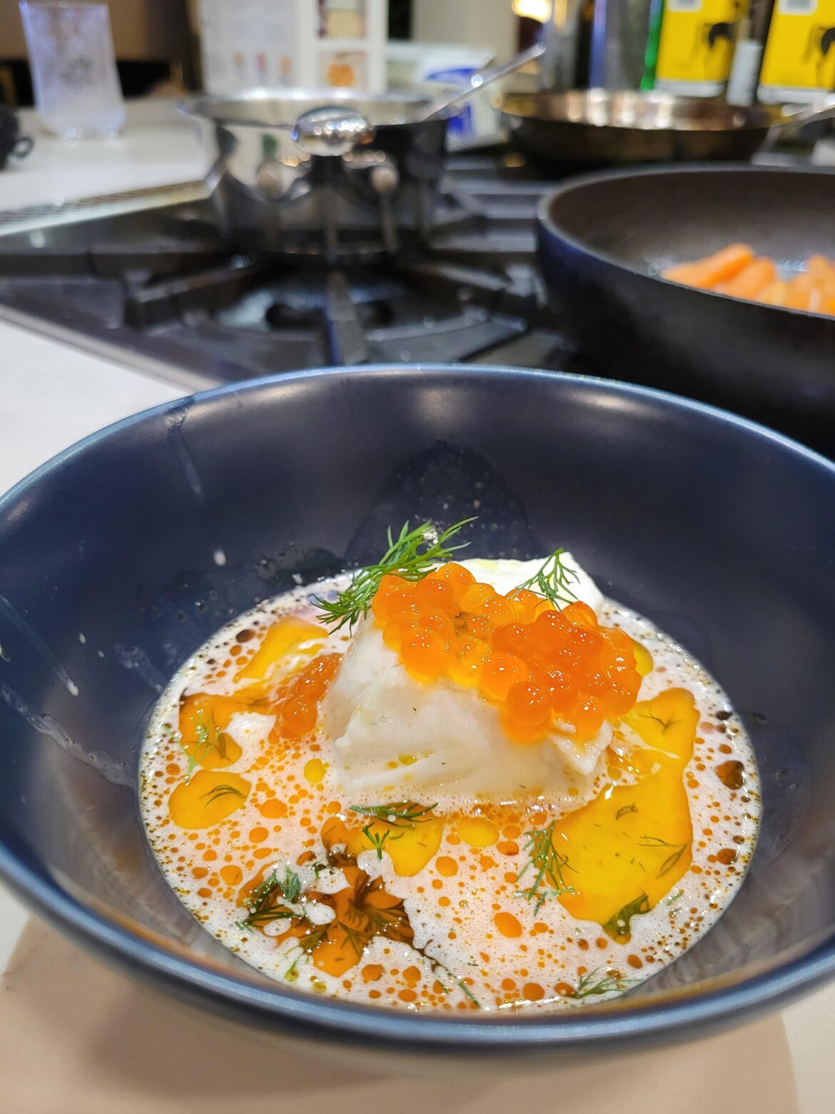 Butter poached halibut with salmon roe, garnished with chili oil and dill